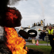 Protesters stoke a fire with tires and block the access to the Exxon Mobil refinery in France. It is also a metaphor for how Exxon treats the atmosphere.